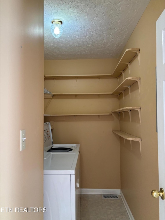 washroom with washer and dryer and a textured ceiling