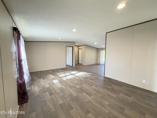 empty room with recessed lighting, a textured ceiling, crown molding, and wood finished floors