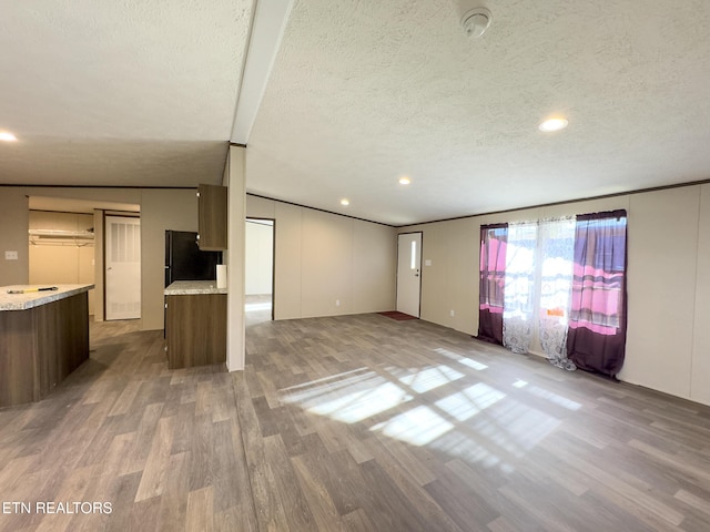 unfurnished living room featuring light wood-style floors and a textured ceiling