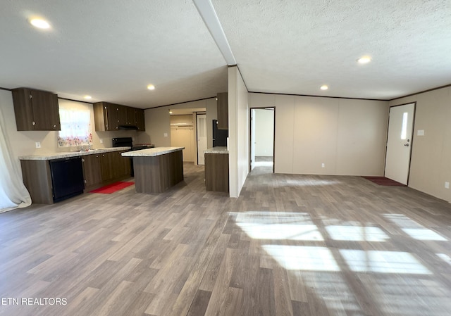 kitchen featuring light wood finished floors, black appliances, light countertops, under cabinet range hood, and a textured ceiling