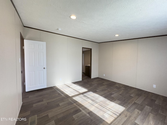 empty room with wood finished floors, visible vents, recessed lighting, a textured ceiling, and crown molding