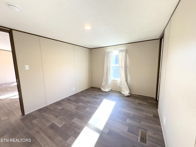 unfurnished bedroom featuring visible vents and wood finished floors