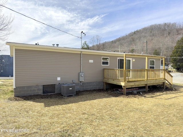 back of property featuring a deck and cooling unit