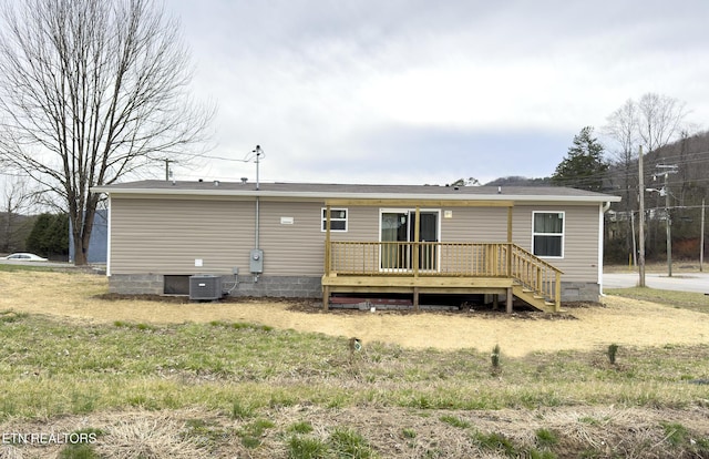 rear view of property featuring cooling unit and a deck