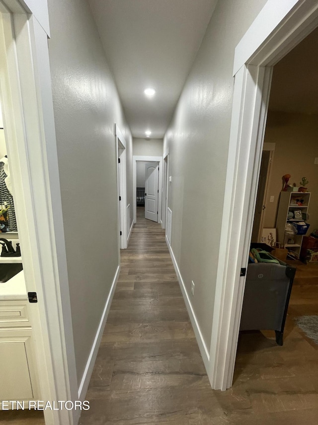 corridor featuring sink and dark hardwood / wood-style flooring