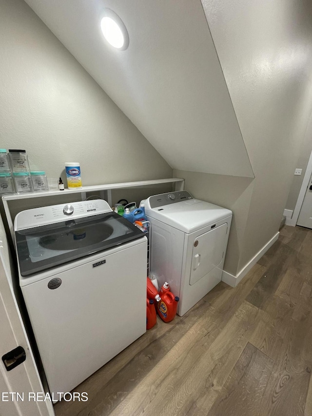 laundry area featuring hardwood / wood-style flooring and washing machine and clothes dryer