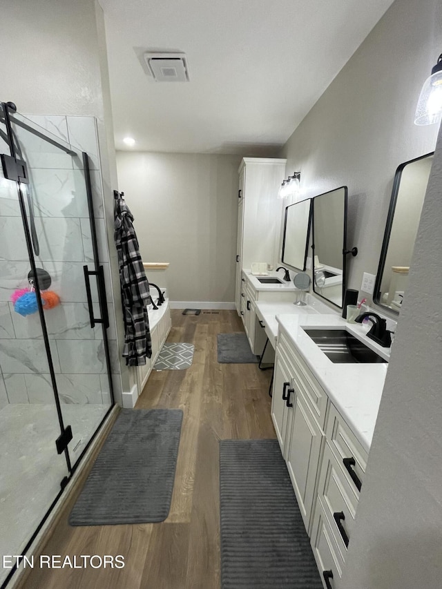 bathroom featuring vanity, wood-type flooring, and independent shower and bath