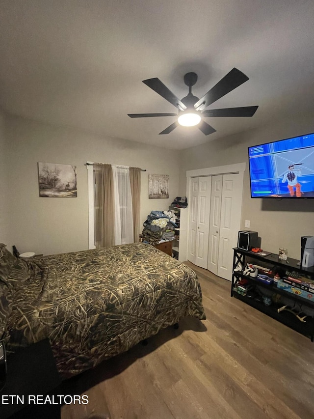 bedroom with ceiling fan, wood-type flooring, and a closet