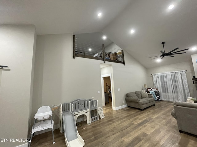 living room featuring wood-type flooring, ceiling fan, and high vaulted ceiling