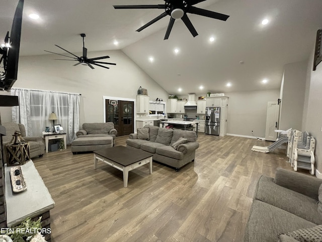 living room with ceiling fan, high vaulted ceiling, and light hardwood / wood-style floors