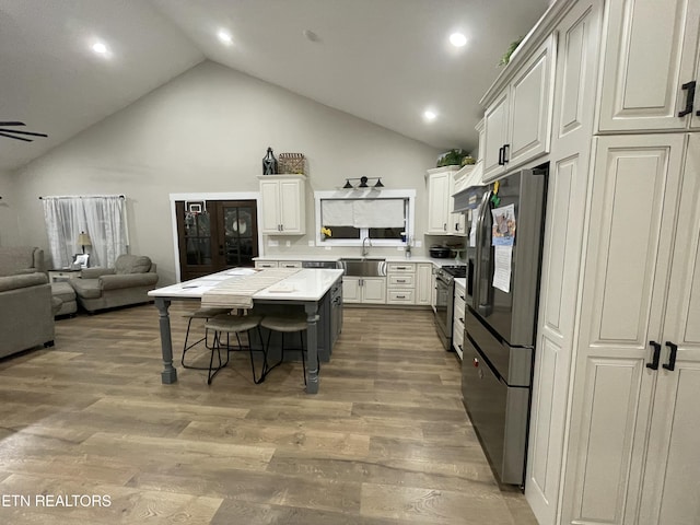 kitchen featuring sink, hardwood / wood-style floors, white cabinets, and appliances with stainless steel finishes