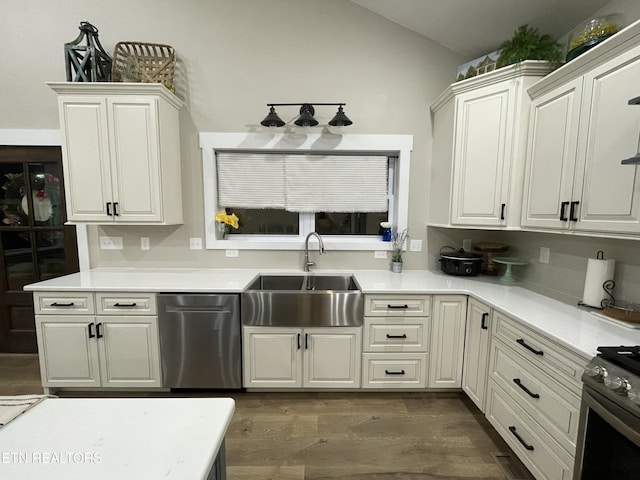 kitchen featuring stainless steel appliances, white cabinetry, sink, and dark hardwood / wood-style flooring