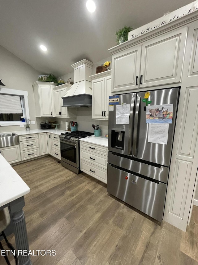 kitchen with sink, appliances with stainless steel finishes, white cabinetry, dark hardwood / wood-style flooring, and custom exhaust hood