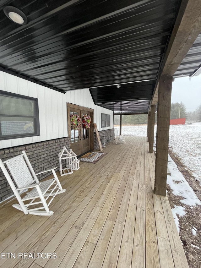 snow covered deck with french doors