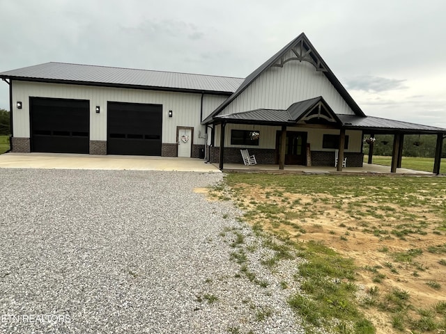 136 Falling Leaf Rd, Jamestown, TN 38556 - view of front of property with metal roof, driveway, covered porch, board and batten siding, and a garage