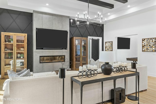 living room featuring a fireplace, beamed ceiling, and light wood-type flooring