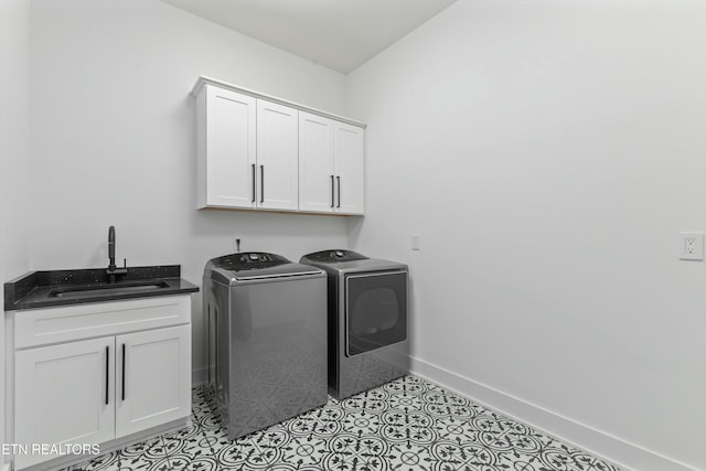 washroom with sink, cabinets, and washer and dryer