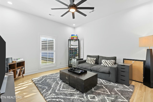 living room featuring light hardwood / wood-style floors and ceiling fan