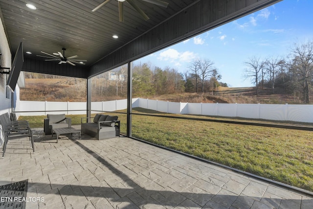 unfurnished sunroom featuring ceiling fan