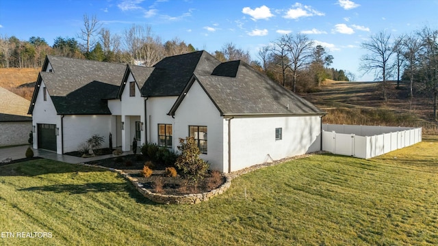 view of side of property featuring a garage and a yard