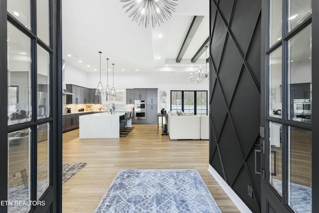 entrance foyer with light hardwood / wood-style floors, sink, and a chandelier