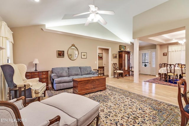 living room with a ceiling fan, lofted ceiling, and light wood-style flooring