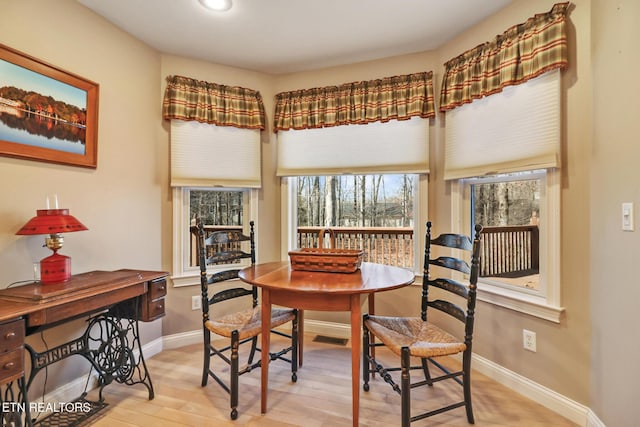 dining room featuring baseboards, visible vents, and light wood finished floors