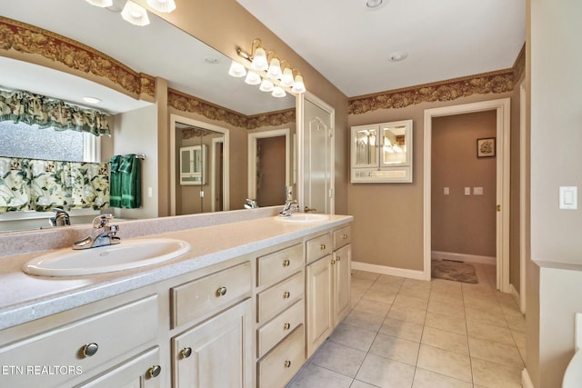 bathroom featuring double vanity, tile patterned flooring, baseboards, and a sink