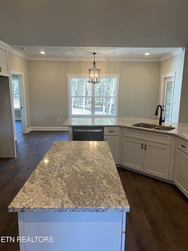 kitchen with dishwasher, sink, decorative light fixtures, white cabinetry, and an island with sink