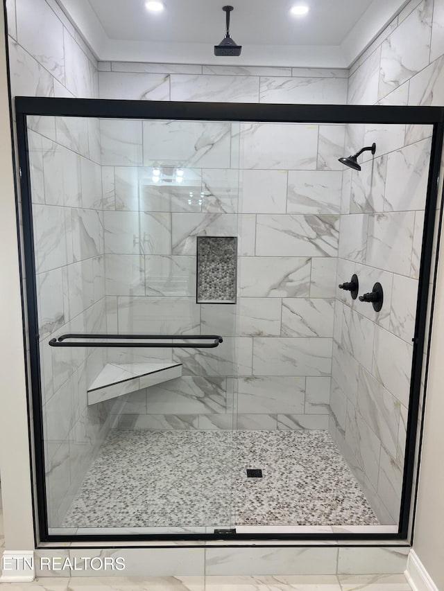 bathroom with a shower with door