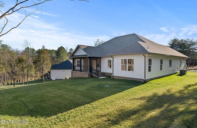 rear view of house with a yard, central AC, and a sunroom