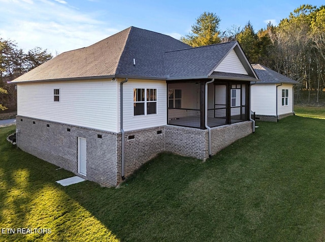 rear view of property with a lawn and a sunroom