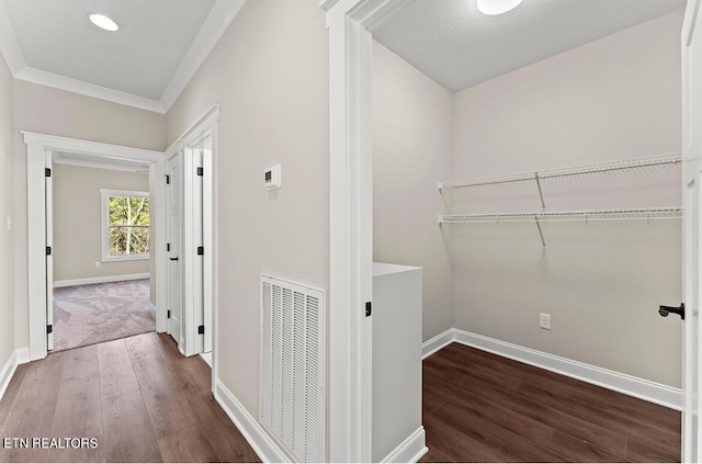 hallway featuring dark hardwood / wood-style flooring and crown molding