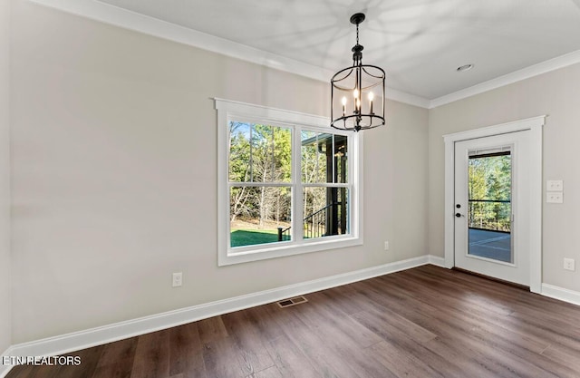 unfurnished dining area featuring dark wood-type flooring, a chandelier, and crown molding