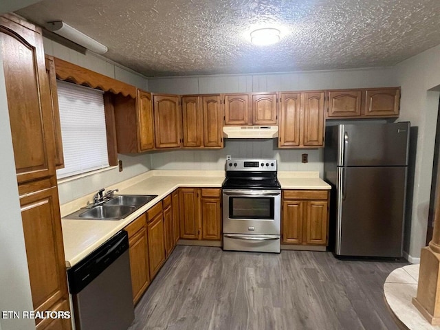 kitchen featuring sink, dark wood-type flooring, a textured ceiling, and stainless steel appliances