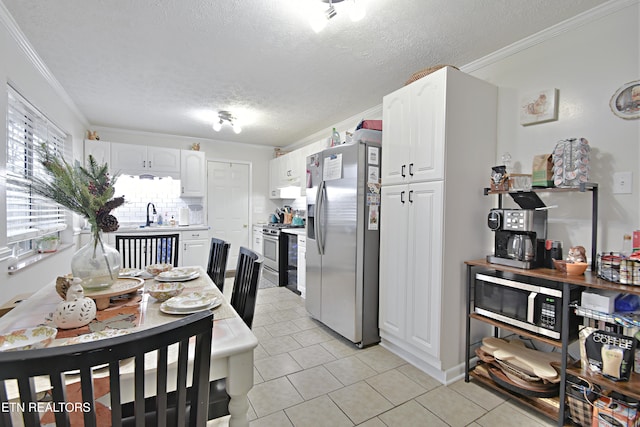 kitchen with crown molding, a textured ceiling, white cabinets, and appliances with stainless steel finishes