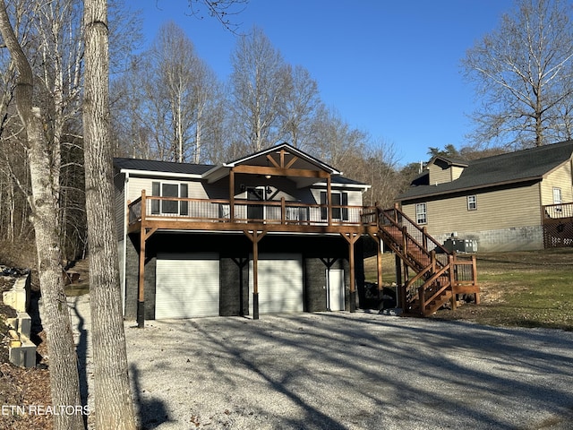 view of front of home featuring a wooden deck, a garage, and central AC