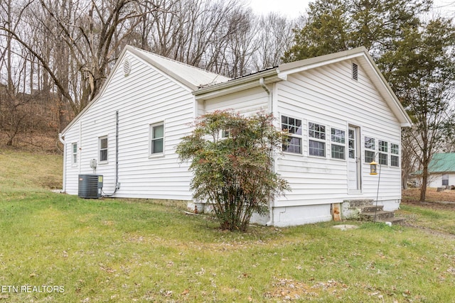 view of side of property with a lawn and central air condition unit