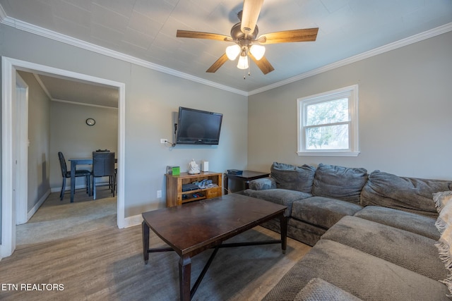 living room with crown molding, wood-type flooring, and ceiling fan