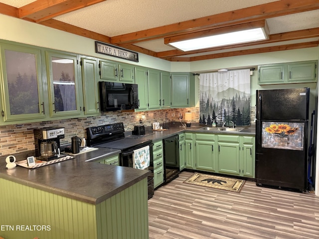 kitchen with sink, black appliances, kitchen peninsula, green cabinets, and backsplash