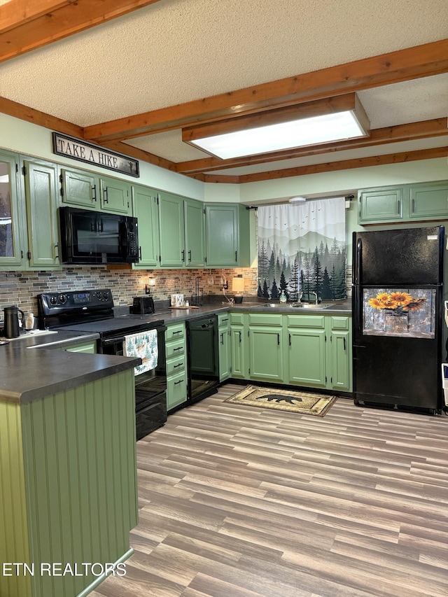 kitchen with sink, a textured ceiling, light wood-type flooring, green cabinets, and black appliances