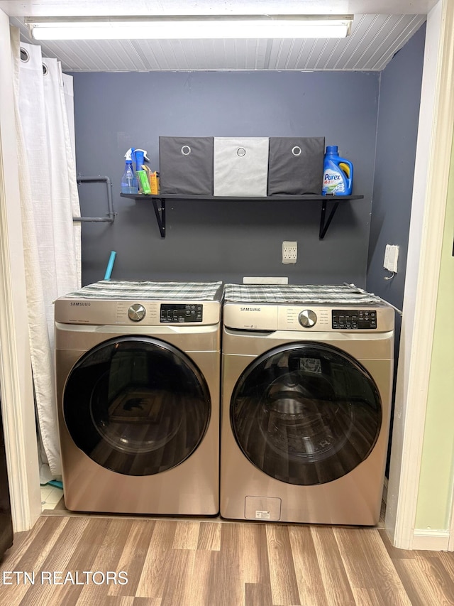 laundry room featuring independent washer and dryer and light hardwood / wood-style flooring