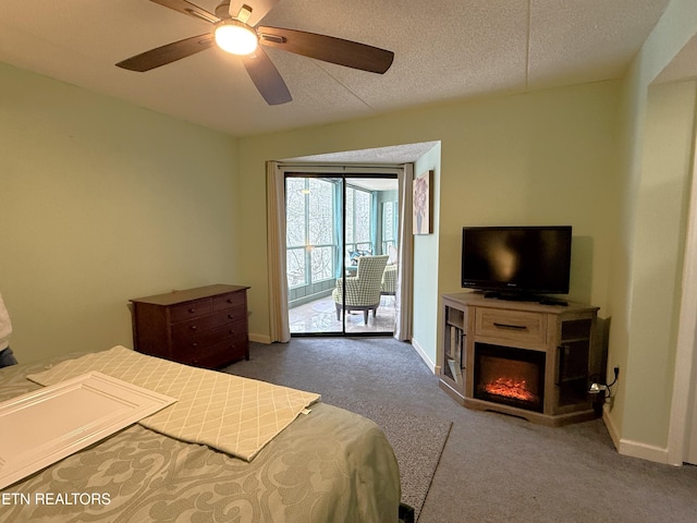 carpeted bedroom with a textured ceiling, access to outside, and ceiling fan