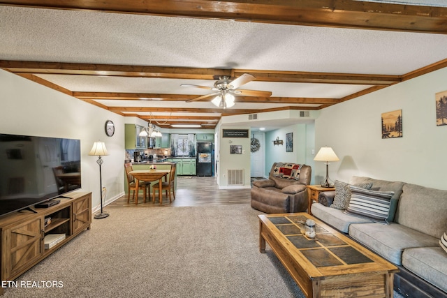 221 Woodland Rd Unit 210, Gatlinburg, TN 37738 - carpeted living area featuring beamed ceiling, a ceiling fan, baseboards, a textured ceiling, and a chandelier