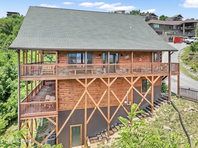 rear view of house featuring a wooden deck