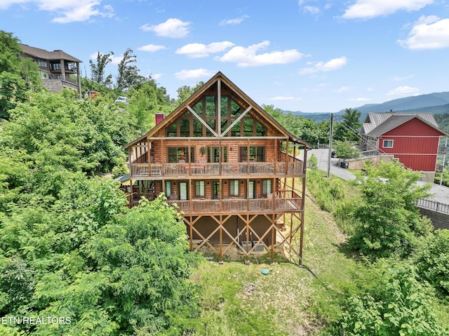 back of property with a deck with mountain view