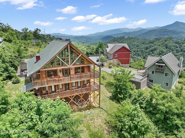 rear view of house with a deck with mountain view