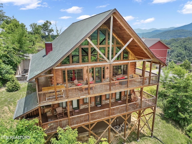 back of property with a deck with mountain view