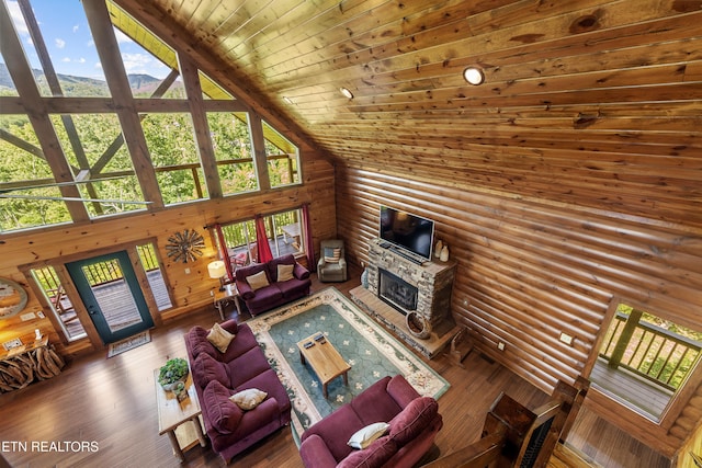 living room with log walls, a fireplace, wood-type flooring, wood ceiling, and high vaulted ceiling