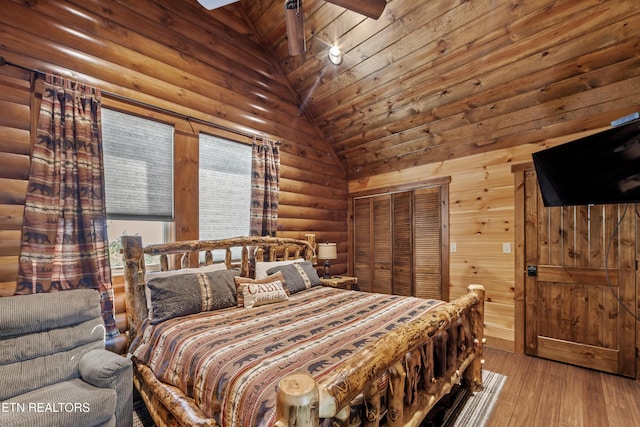 bedroom featuring log walls, wood ceiling, wood-type flooring, a closet, and high vaulted ceiling